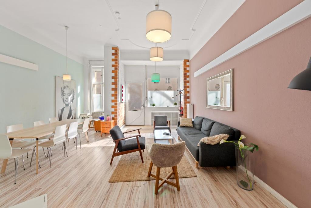 ベルリンにあるprimeflats - Apartments Schillerpark Berlin-Weddingのソファとテーブルと椅子のあるリビングルーム