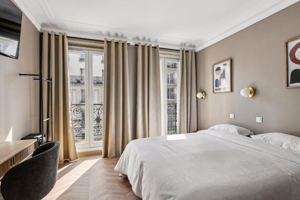 a bedroom with a large bed and a window at Margot in Paris