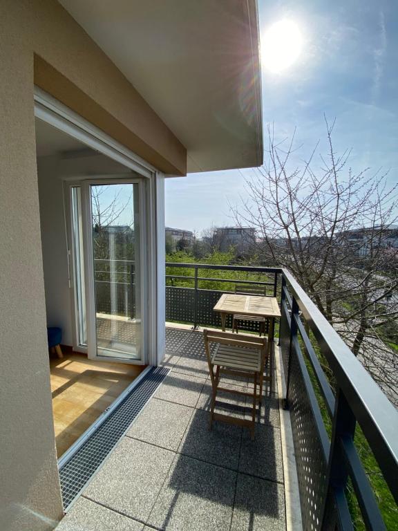 a balcony with a table and a bench on it at Charmant appartement 3 pièces proche RER & Disney in Montévrain