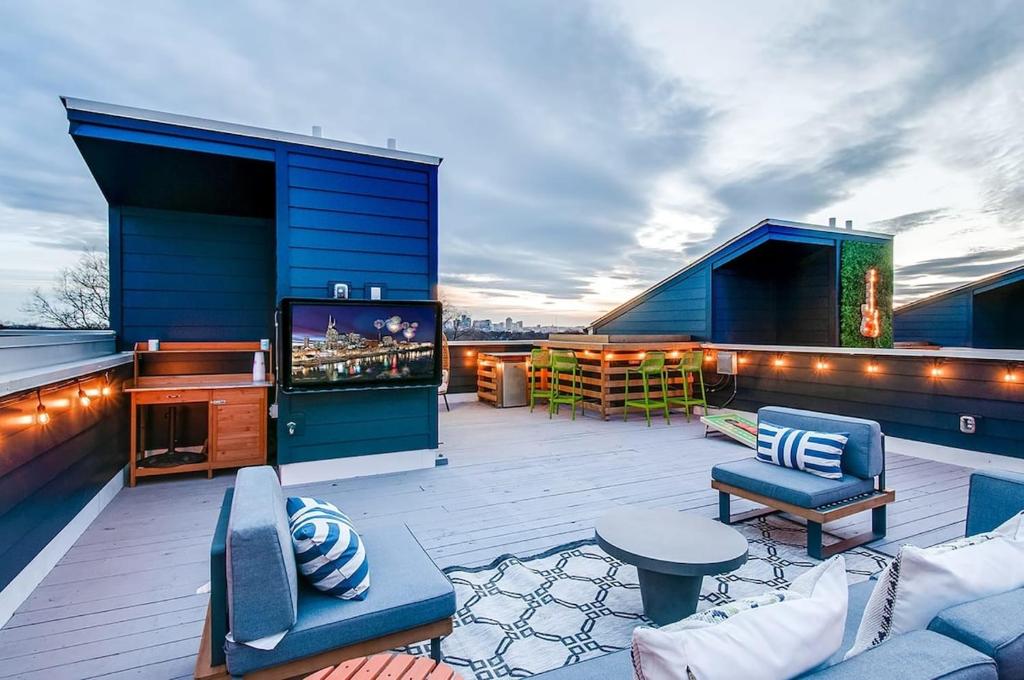 een patio met een televisie en meubels op een dak bij East Nash Lux - 13 Beds & City Views in Nashville