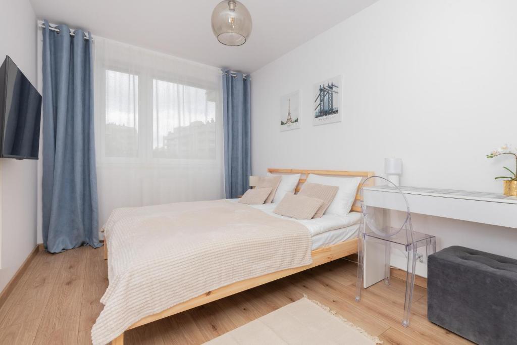 a white bedroom with a bed and a window at Bright Apartment with Private Garden and Accepting Pets by Renters in Gdańsk