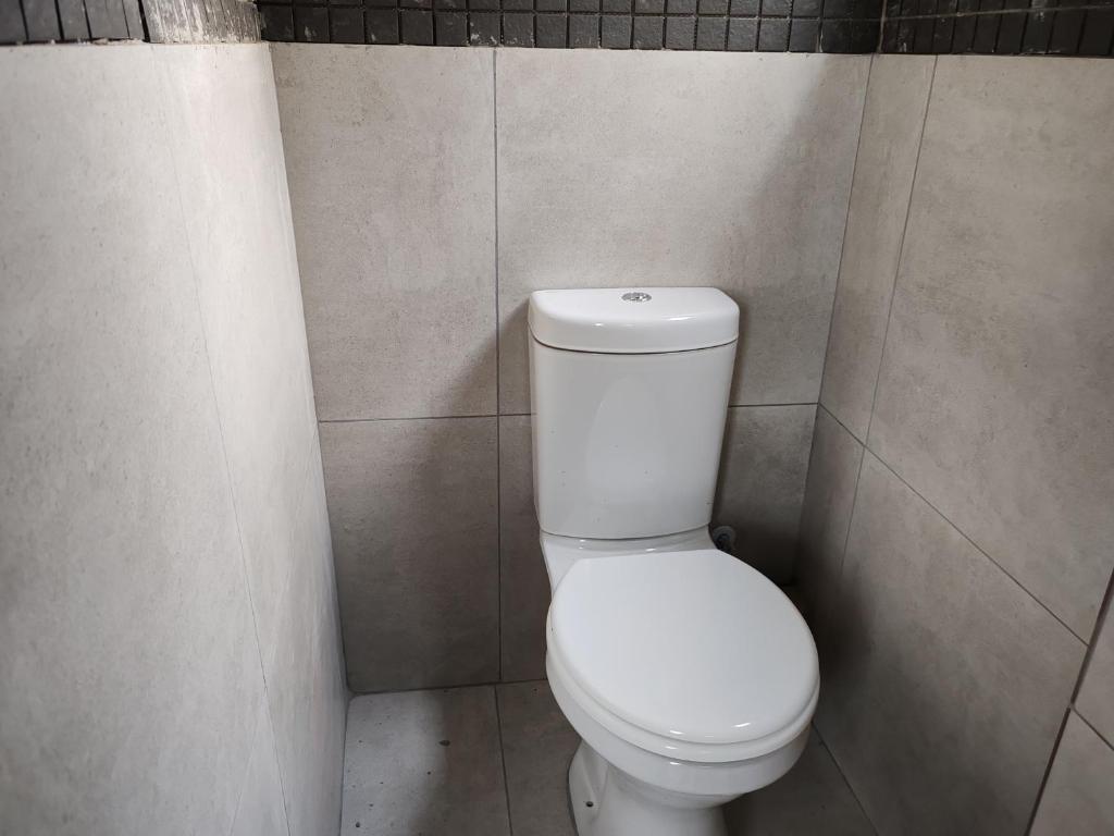 a bathroom with a white toilet in a stall at Sem's Guest Cottage in Edenvale