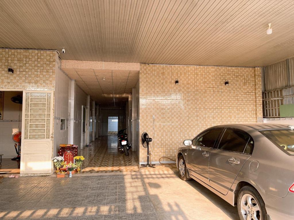 un'auto argentata parcheggiata davanti a un edificio di Nhà Nghỉ Tấn Phát a Ấp Thanh Sơn (1)