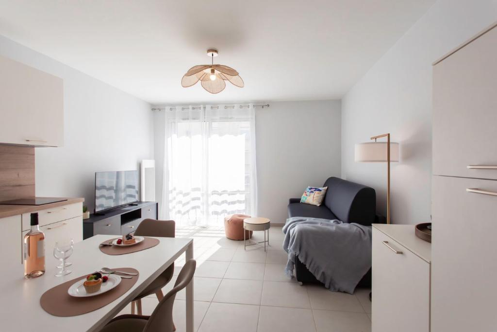 un salon blanc avec une table et un canapé dans l'établissement A5 - Modern Studio 5 min to Sea - Pool & Garage, à Antibes