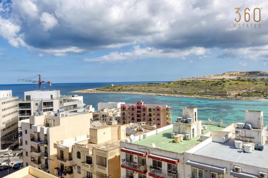 - une vue sur la ville et l'océan avec ses bâtiments dans l'établissement Beautiful 2BR Penthouse with Private Terrace & BBQ by 360 Estates, à San Pawl il-Baħar