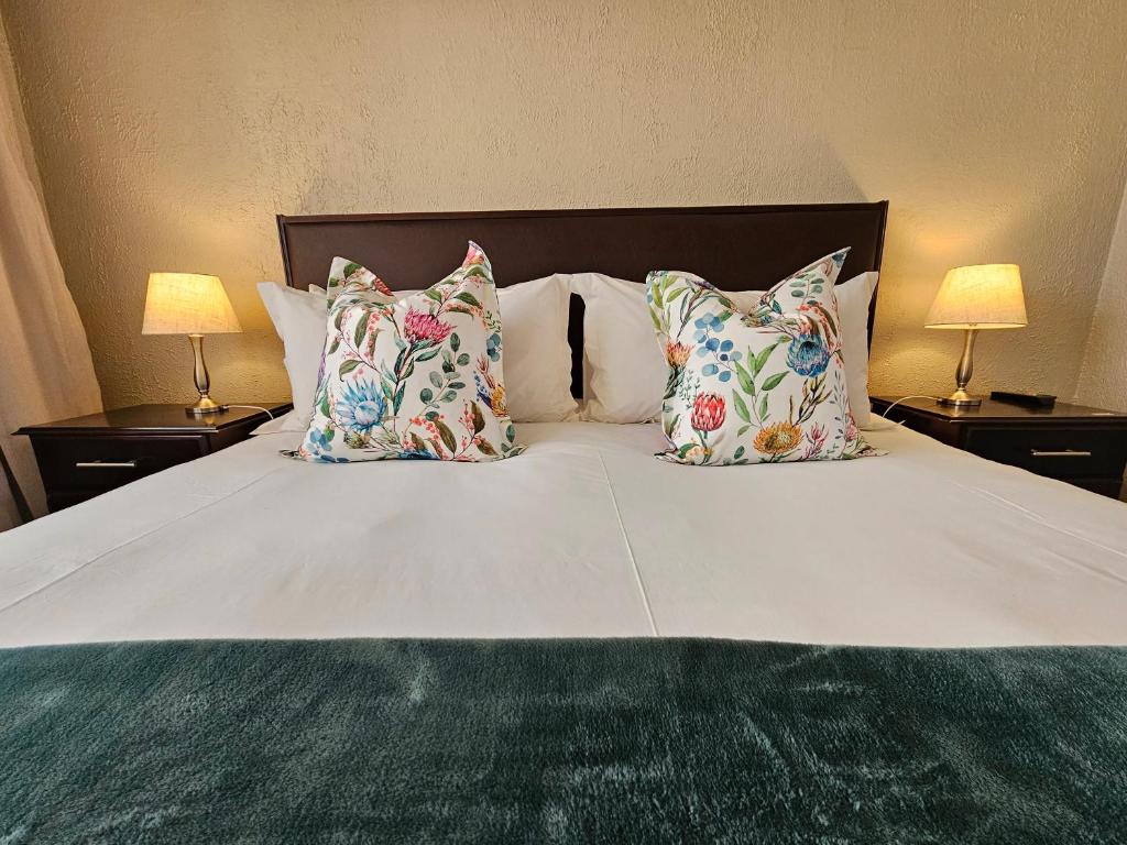 duże białe łóżko z poduszkami i 2 lampami w obiekcie Aloes 1st on Camp w mieście Middelburg