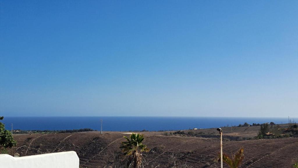 ein leeres Feld mit dem Ozean im Hintergrund in der Unterkunft Inviting 1-bedroom house 'Esquina' Finca Vistamar in Salobre