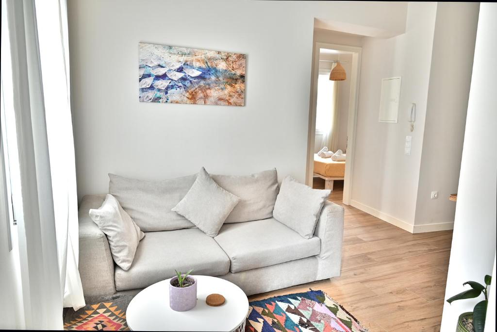 een woonkamer met een bank en een schilderij aan de muur bij Old Town Apartment in Corfu-stad