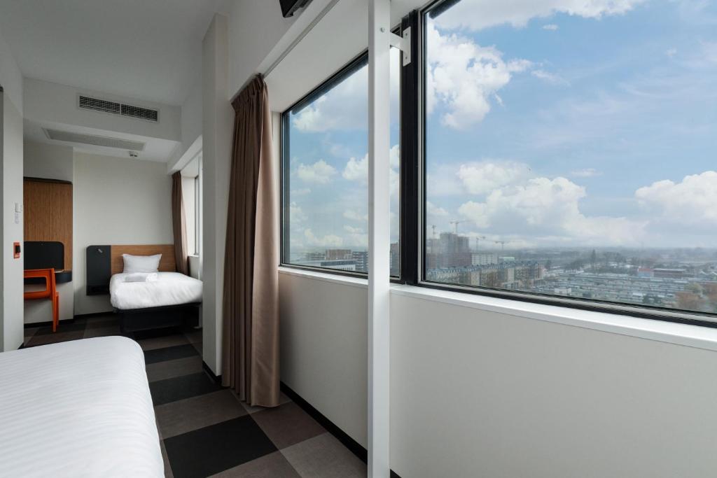 a bedroom with a bed and a large window at easyHotel Amsterdam Zaandam in Zaandam