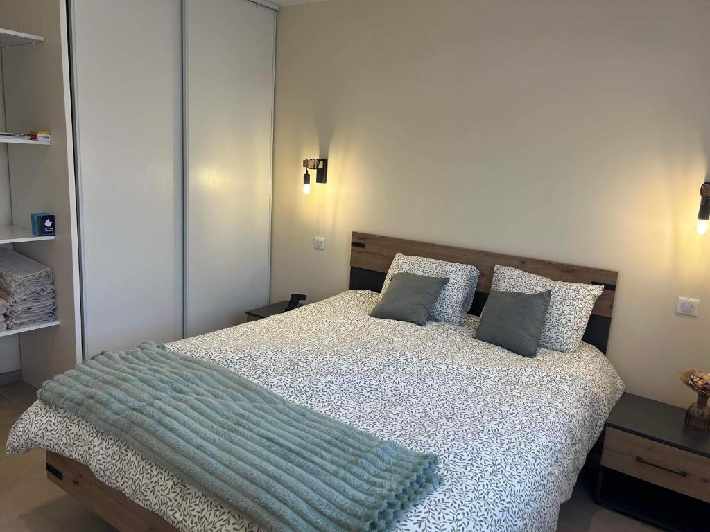 een slaapkamer met een bed met een blauwe deken erop bij Gîte de Mam's - Voie verte in Bazeilles