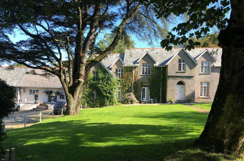 a large house with a large green lawn at Exmoor Manor Guest House in Lynton