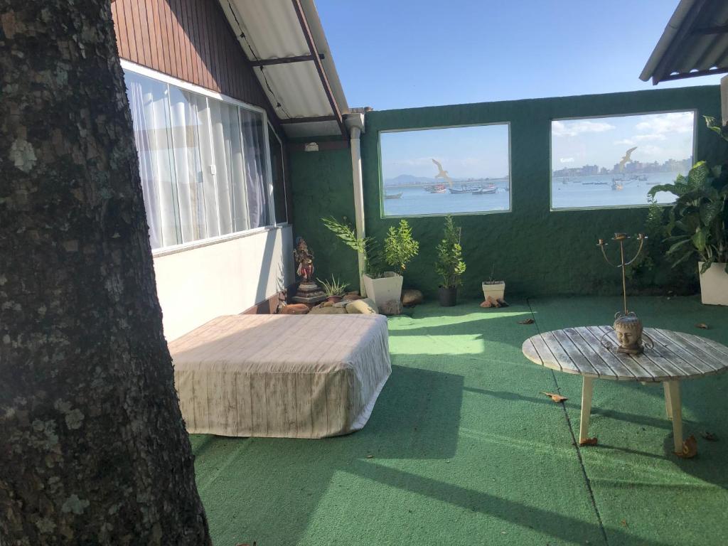 um quarto com uma cama, uma mesa e janelas em Cabanas São Miguel em Penha