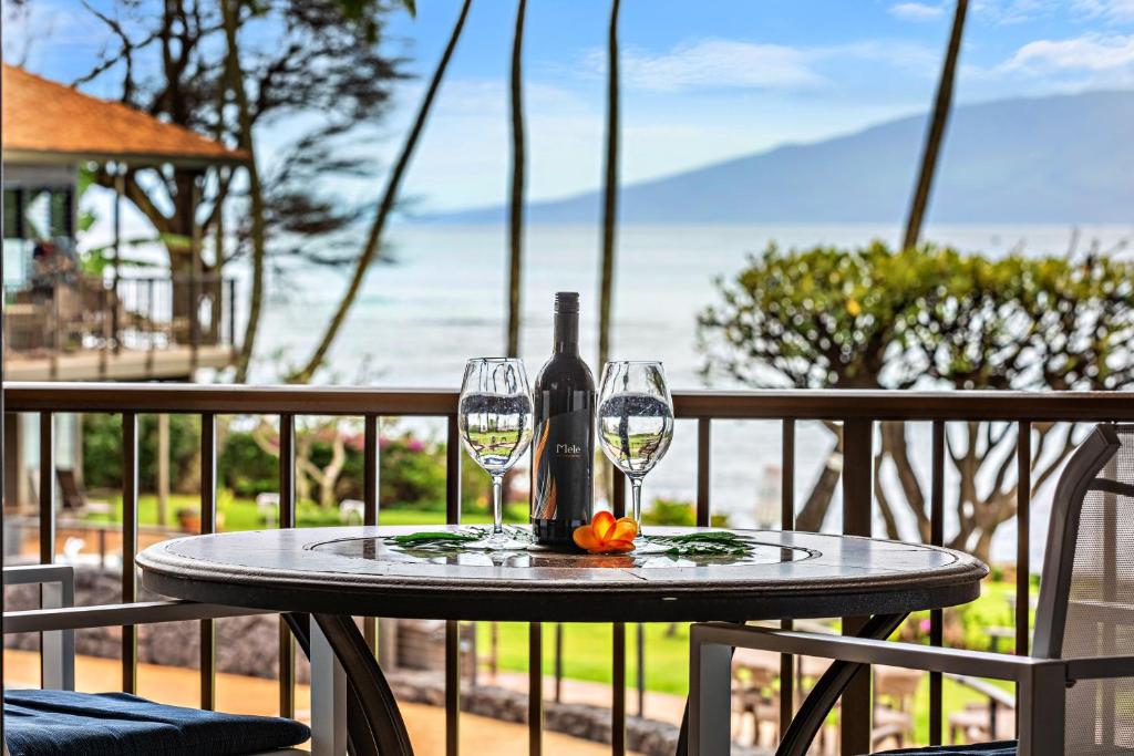 a table with two glasses and a bottle of wine at Polynesian Shores 205 in Kahana