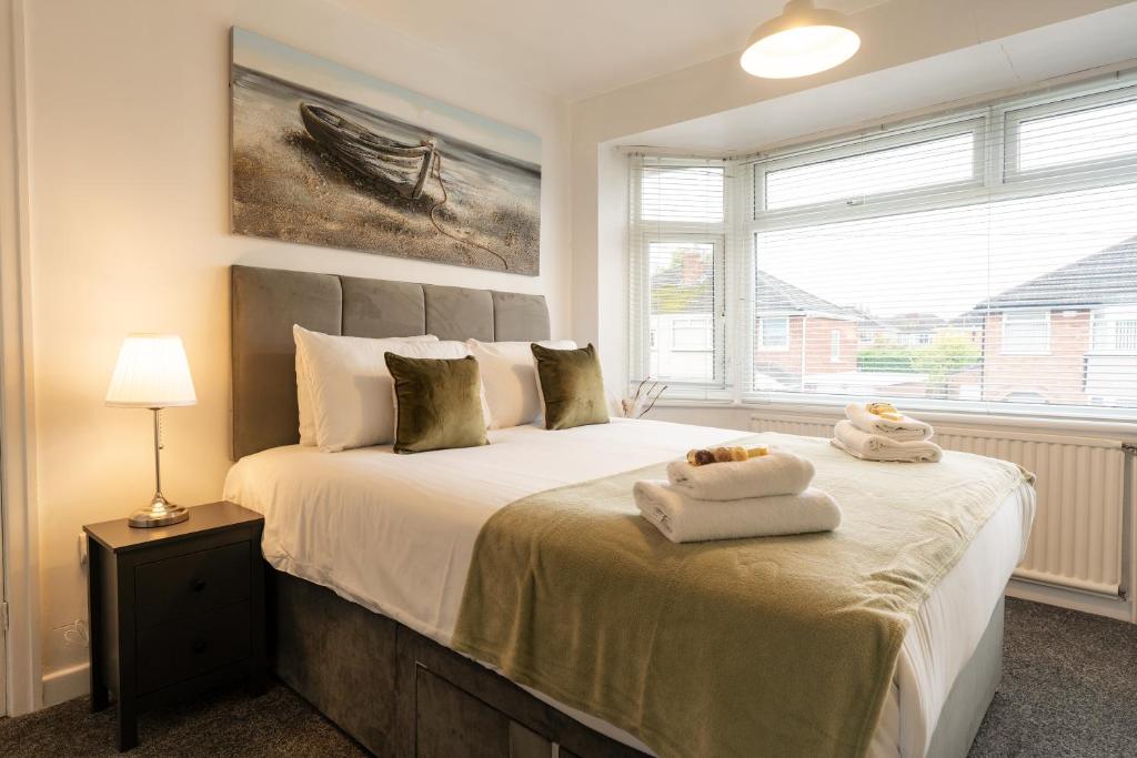 a bedroom with a bed with two towels on it at Lovely 3 Bed Home in Ellesmere Port - With Parking - Sleeps 5 in Sutton