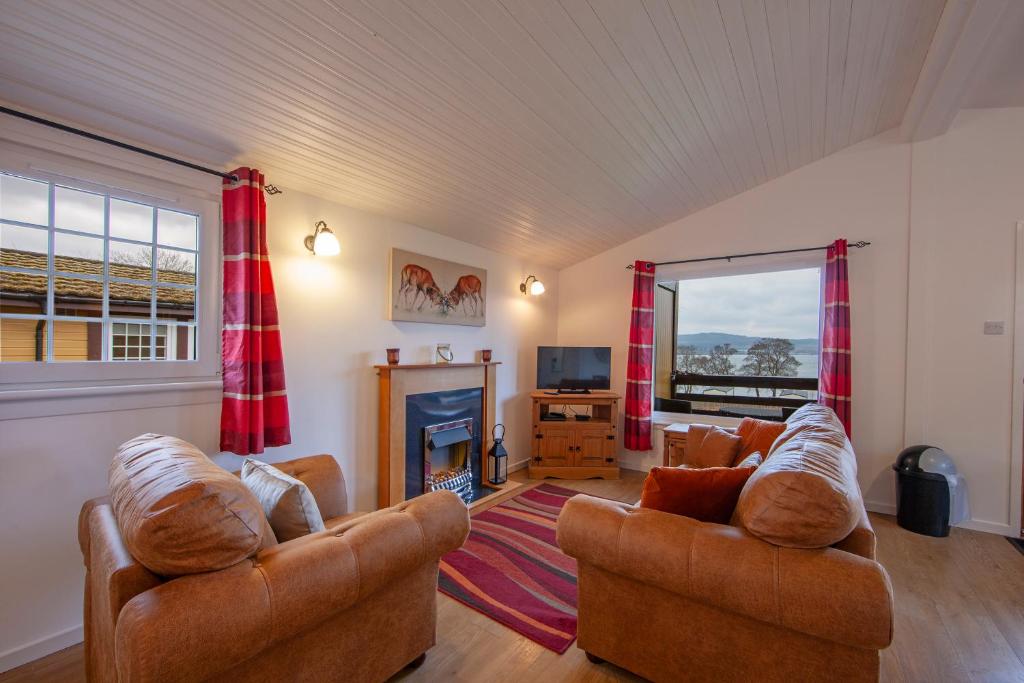 a living room with two couches and a fireplace at Appin Holiday Homes in Appin