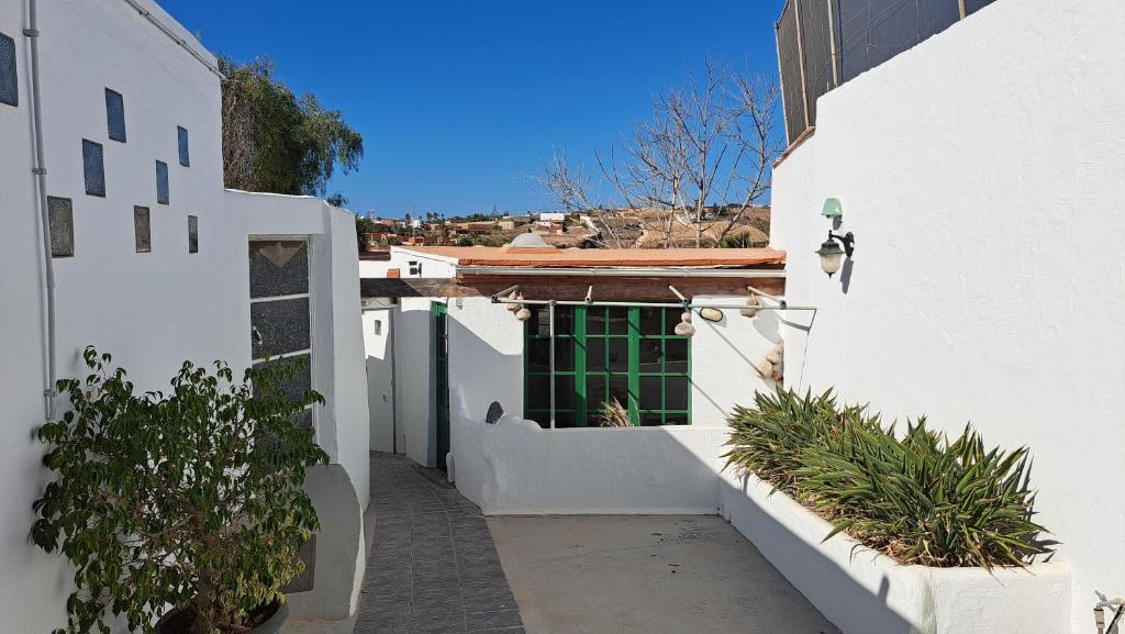 eine Gasse mit grüner Tür in einem weißen Gebäude in der Unterkunft Beautiful 1-Bed House 'Oficina' Finca Vistamar in Salobre