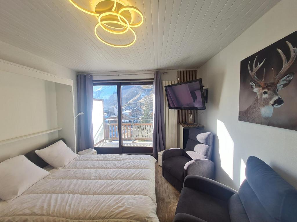 une chambre d'hôtel avec deux lits et une télévision dans l'établissement Lauvitel - J6 - Appt pres des pistes 6 pers, à Les Deux Alpes