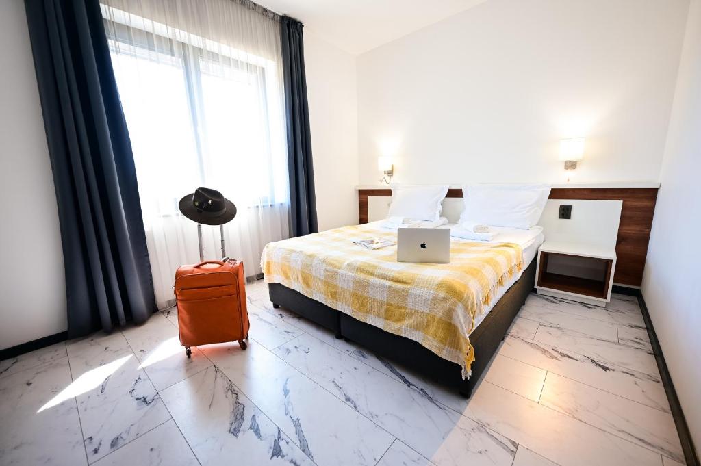 a hotel room with a bed with a laptop on it at RUBO Hotel in Shumen