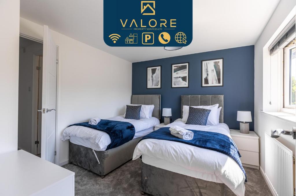 twee bedden in een slaapkamer met blauwe muren bij Cosy 5 bedroom house - Central By Valore Property Services in Loughton