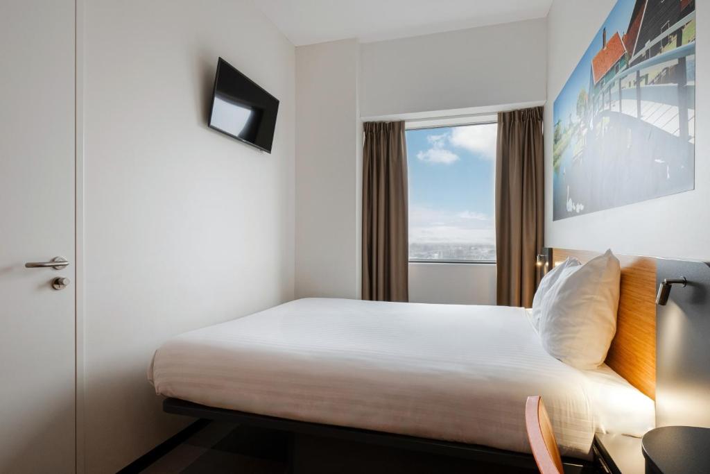 a hotel room with a bed and a window at easyHotel Amsterdam Zaandam in Zaandam