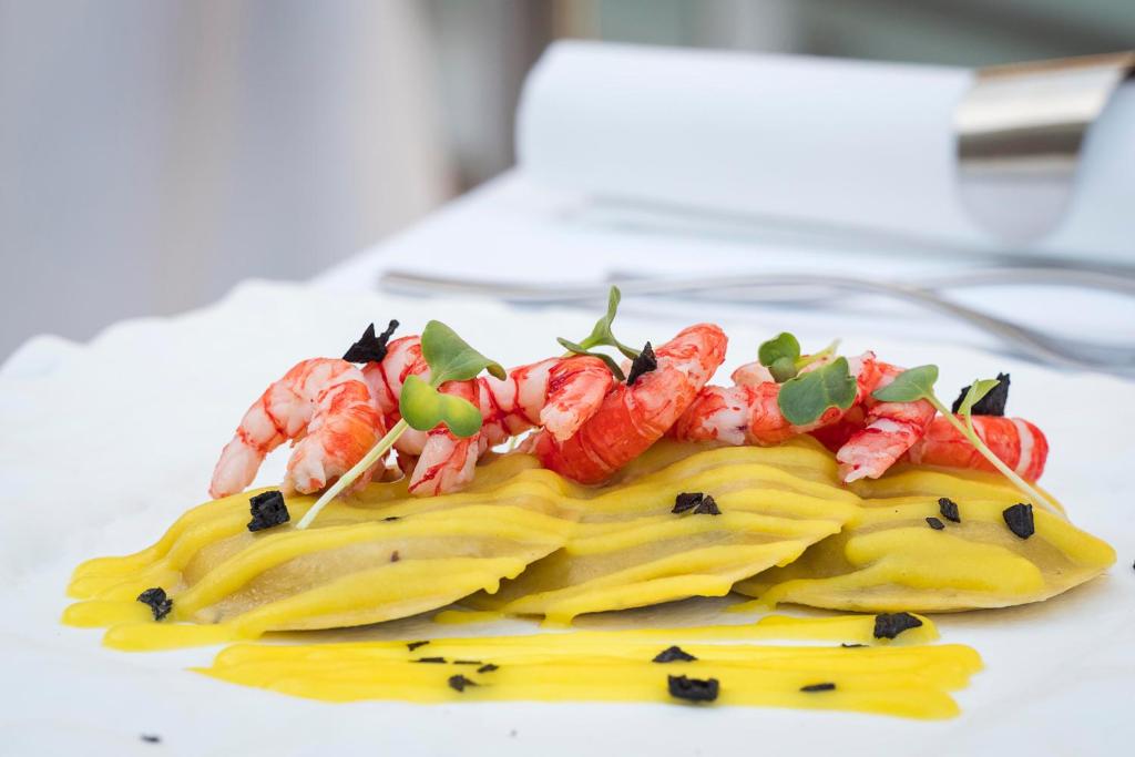 a plate of food with shrimp on top of pasta at Albatros Beach Hotel in Letojanni