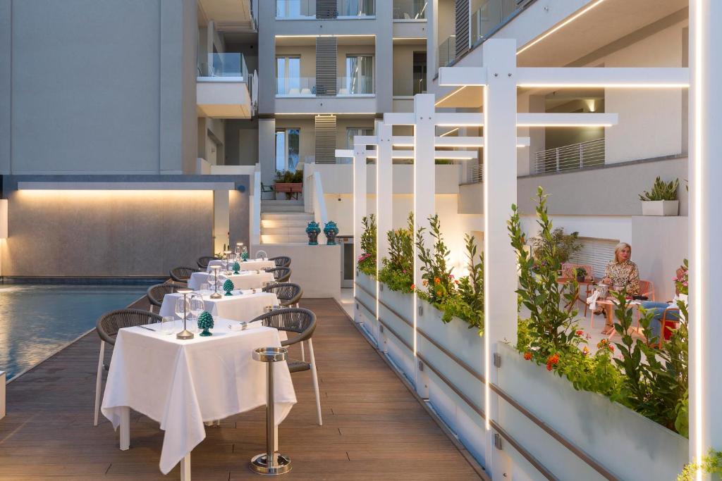 a restaurant with tables and chairs and a pool at Albatros Beach Hotel in Letojanni