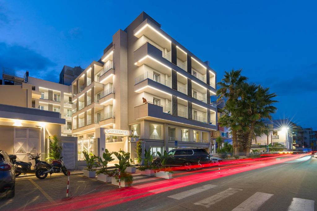 a large white building with cars parked in front of it at Albatros Beach Hotel in Letojanni