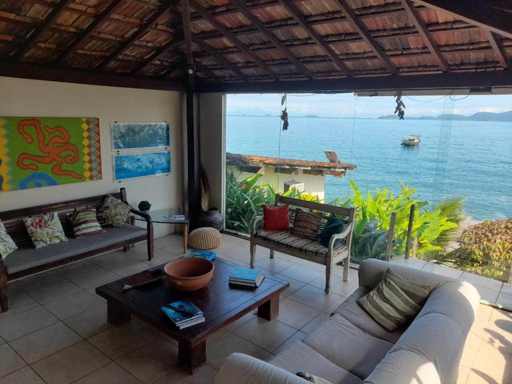 a living room with a view of the ocean at Suites Ponta Leste in Angra dos Reis