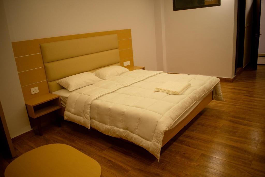 a bedroom with a large bed with a wooden floor at The Grand ARK in Gangtok