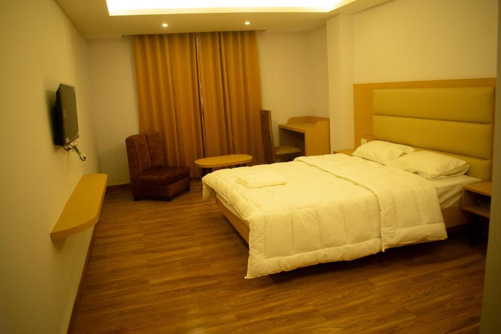 um quarto de hotel com uma cama e uma televisão em The Grand ARK em Gangtok