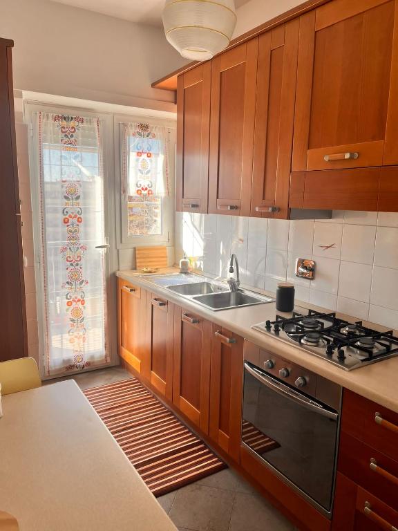 uma cozinha com armários de madeira, um fogão e um lavatório em CASINA APPIA apartment em Roma
