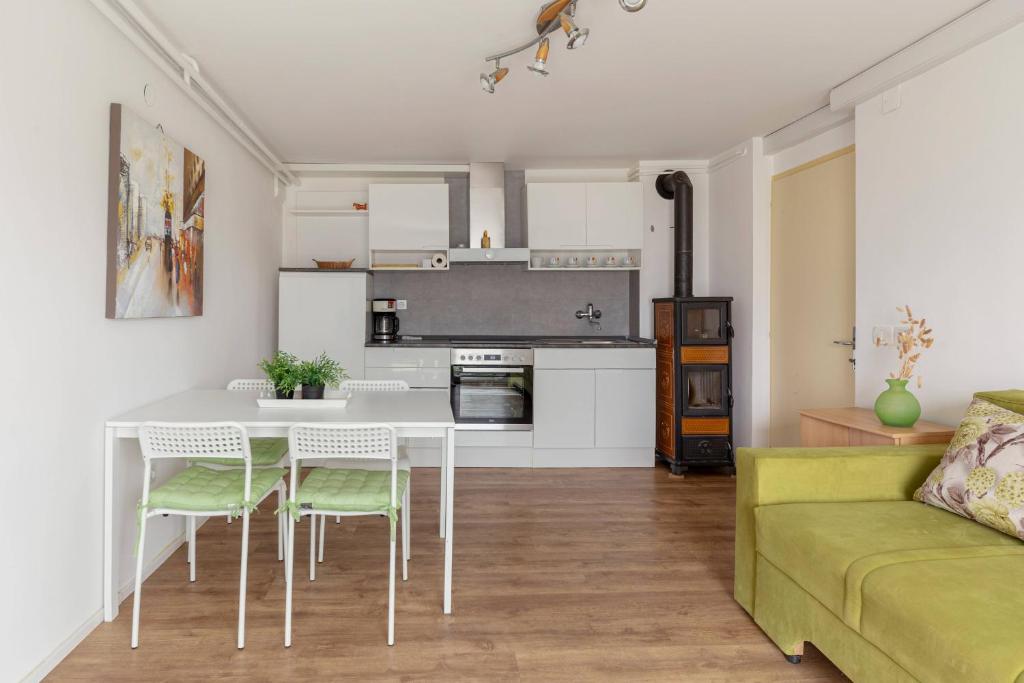 cocina y sala de estar con mesa y sillas en Apartments Žnidar, en Spodnje Gorje