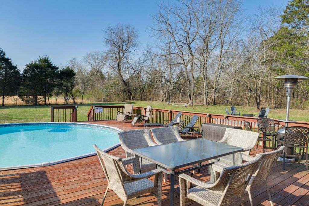 a deck with a table and chairs next to a pool at Spacious Lebanon Home with Pool 6 Mi to Downtown! in Lebanon