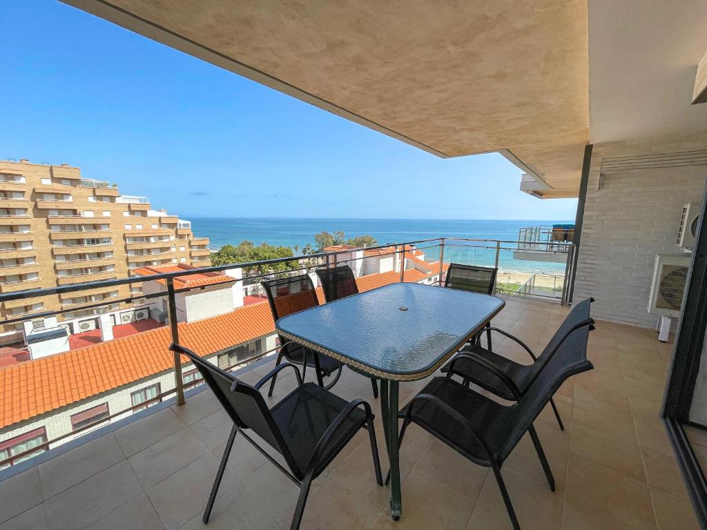a table and chairs on a balcony with the ocean at Oropesa Ciudad de Vacaciones 3000 in Oropesa del Mar
