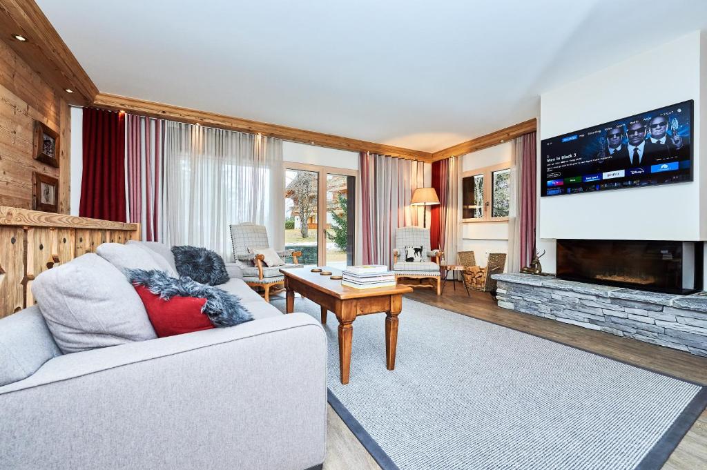 a living room with a couch and a tv at Route de Tsarbouye 17, 4BR, Les Dauphinelles in Crans-Montana