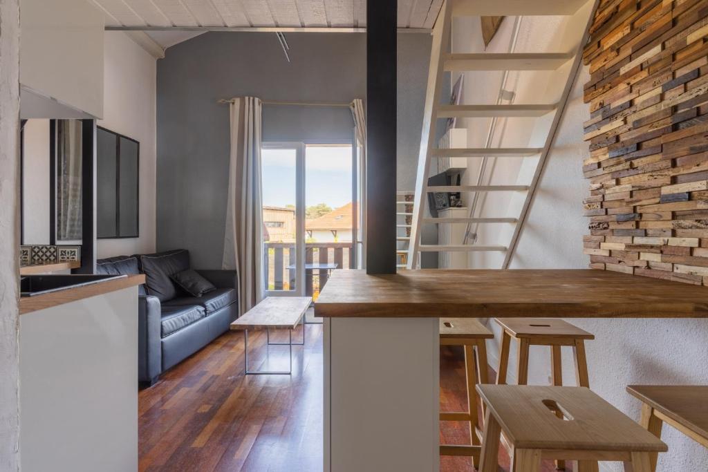 una cocina y una sala de estar con una escalera de caracol en un loft en charmant Studio mezzanine, en Biscarrosse