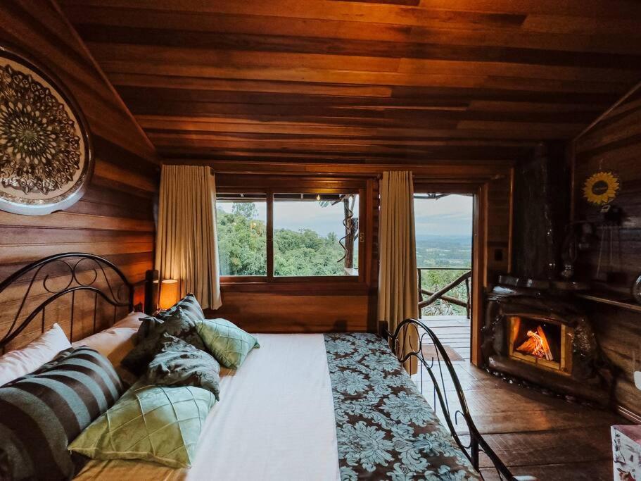 a bedroom with a bed with a fireplace and a window at Cabana Alecrim in Bom Princípio