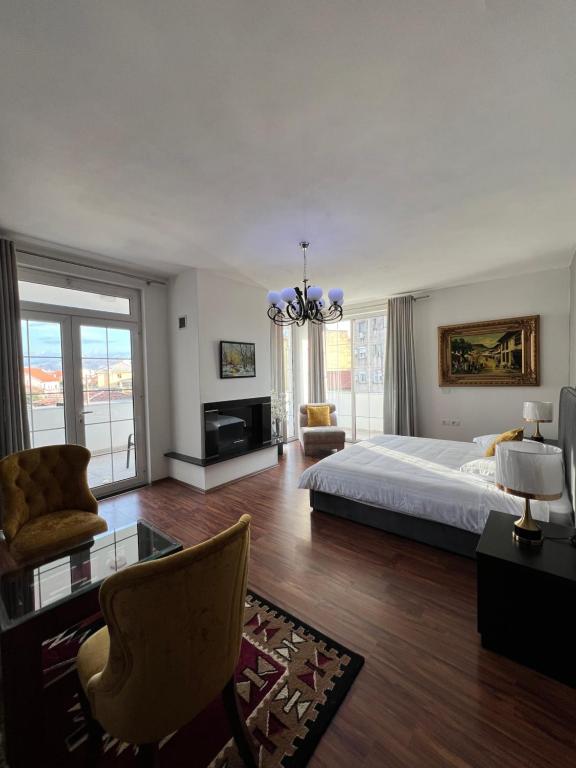 um quarto grande com uma cama e um lustre em North Star Hostel em Shkodër