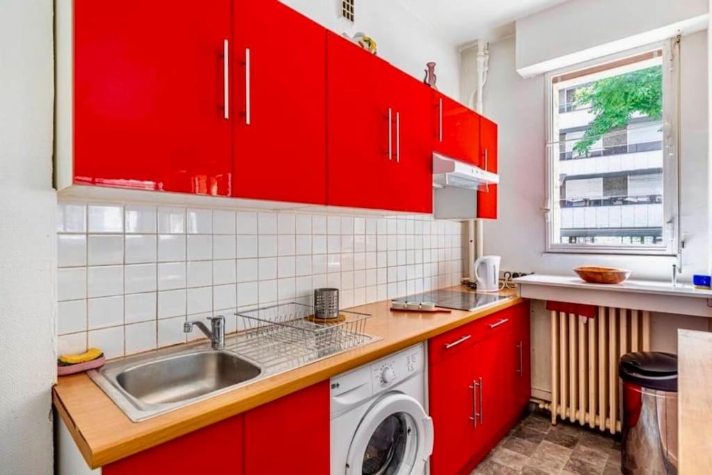 a red kitchen with a sink and a washing machine at Charmant Appartement 4P Quartier Tour Eiffel in Paris