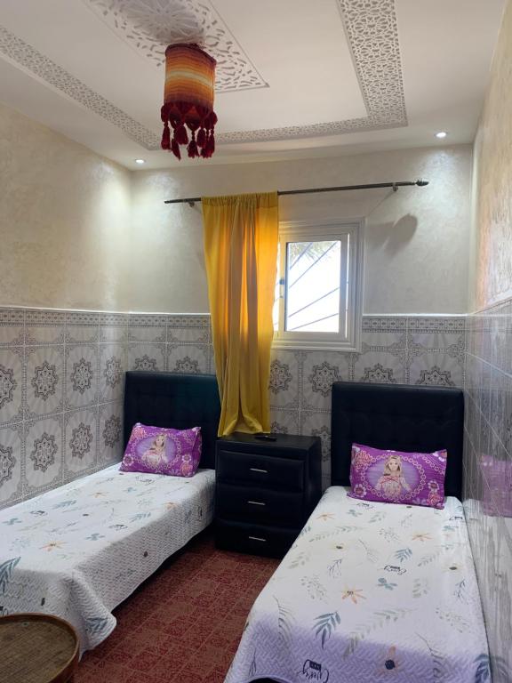 - une chambre avec 2 lits et une fenêtre dans l'établissement Dar Sultan Oualidia, à Oualidia