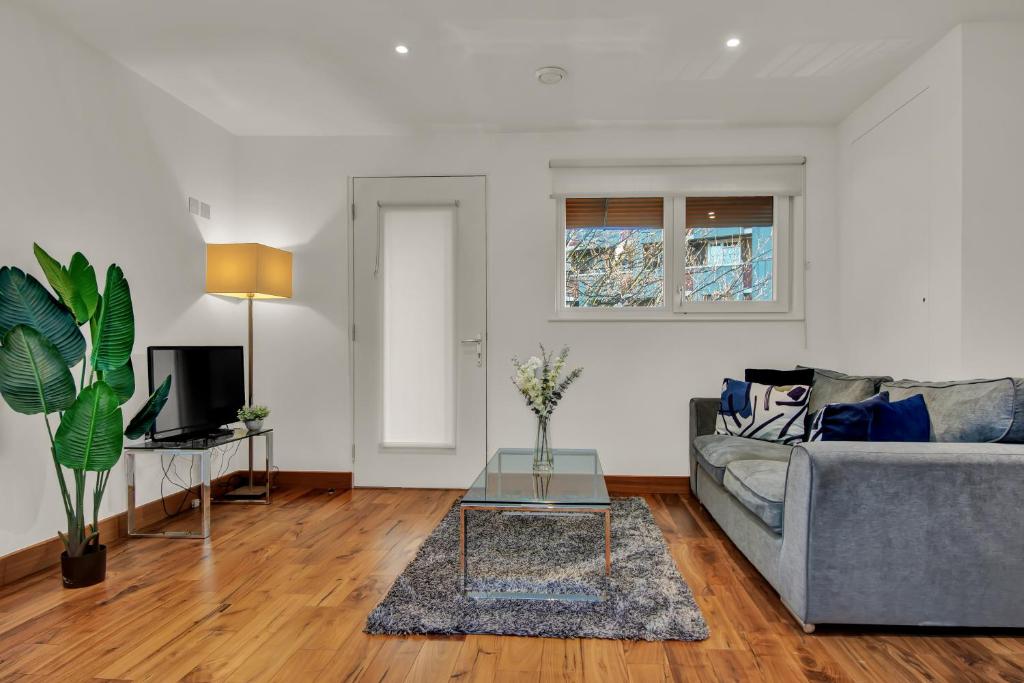 a living room with a couch and a table at Modern Apartments close to Colombia Road Flower Market in London