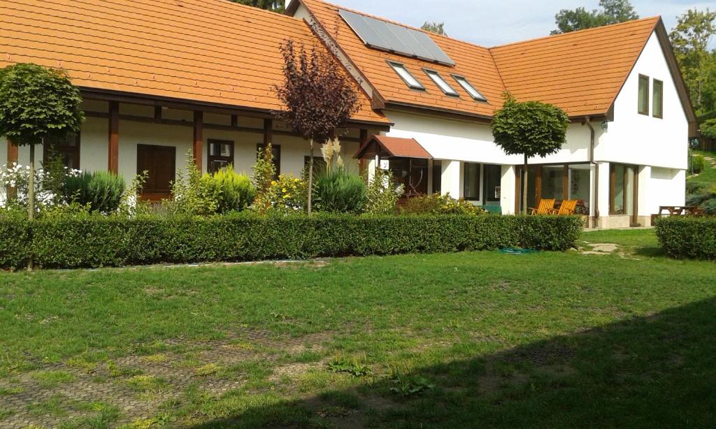 ein Haus mit einem orangenen Dach und einem Hof in der Unterkunft Tip-Top Lak Vendégház in Szilvásvárad