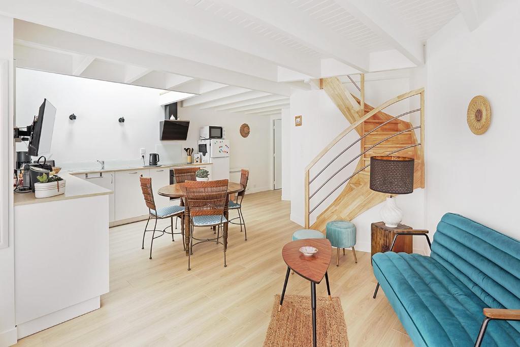 un salon avec un canapé bleu et une table dans l'établissement La Galerie Pornic - Maison Lotus, à Pornic