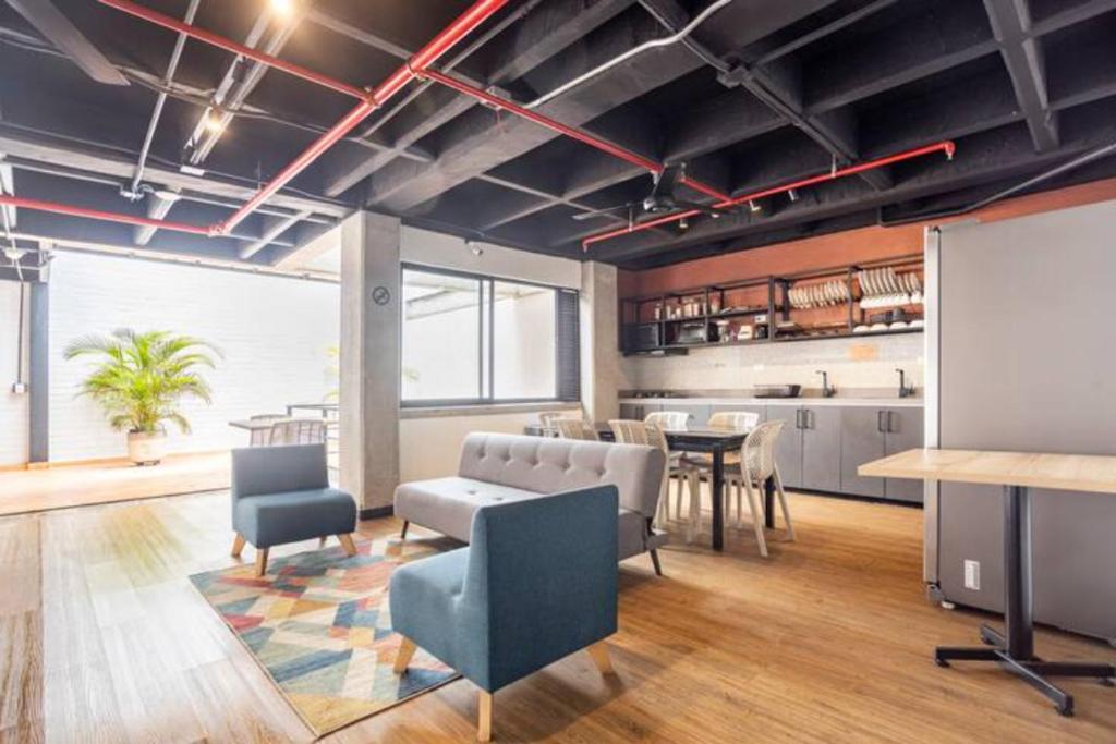 una oficina con sala de reuniones con mesa y sillas en Dormitorios en Medellín con áreas comunes, Coworking - Be Together by Roots Rentals TOG HAB, en Medellín