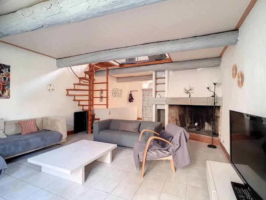 a living room with a couch and a fireplace at Le Temps Suspendu - Maison atypique avec terrasse in Fitou