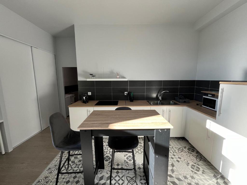 eine Küche mit einem Tisch und 2 Stühlen in der Unterkunft Immeuble La DOA proche CHU in Saint-Priest-en-Jarez