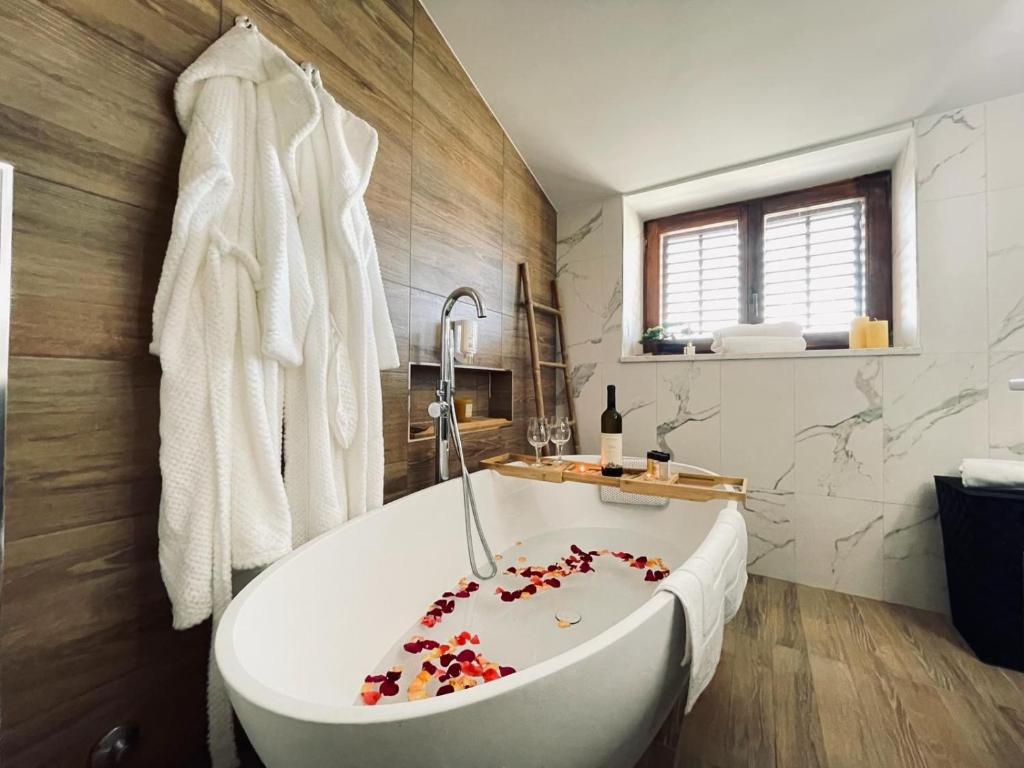 uma casa de banho com uma banheira branca com cerejas em Astraluxe em Fažana