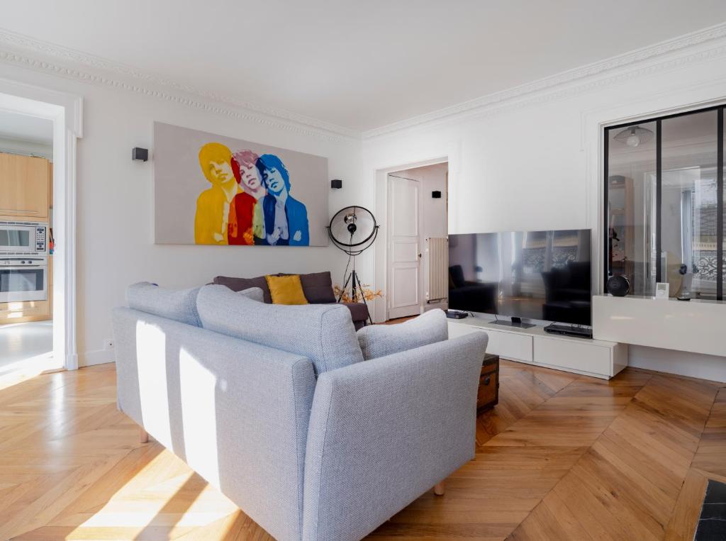 un salon avec un canapé et une télévision dans l'établissement Paris Center - Haussmann Elegant Residence, à Paris