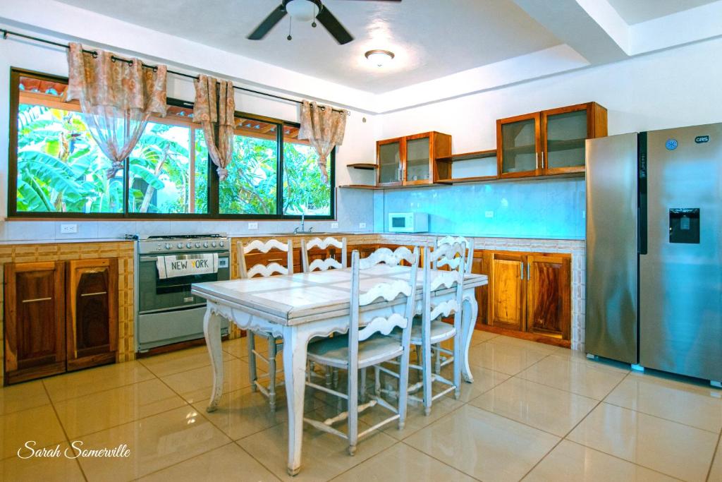 a kitchen with a table with chairs and a refrigerator at 1 Large beautiful poolside condo with AC! Great Location! in Carrillo