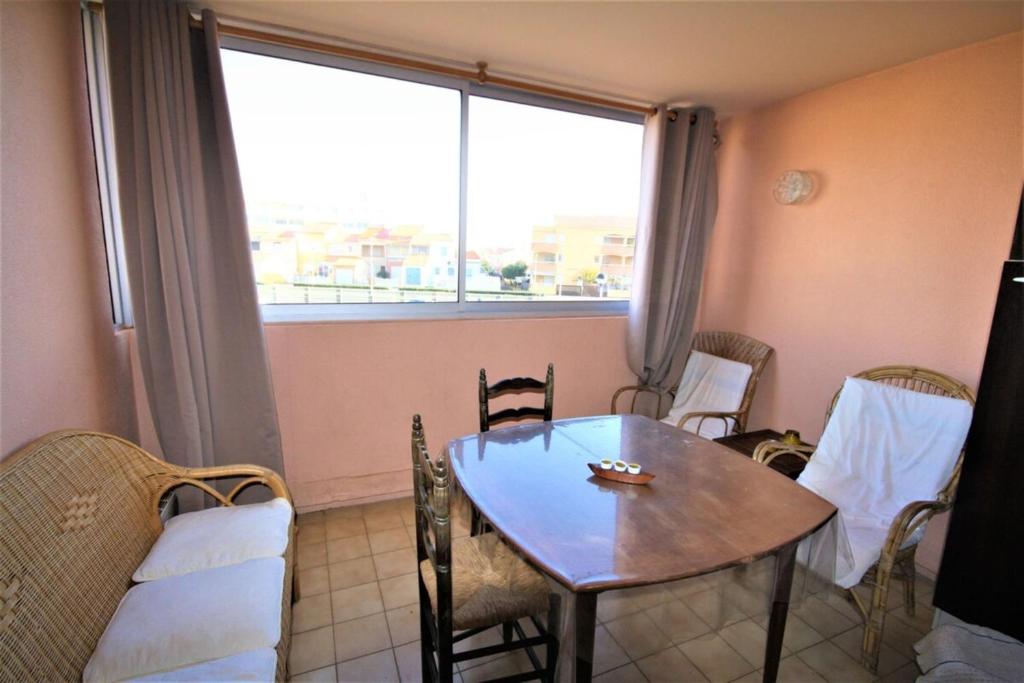 une pièce avec une table, des chaises et une fenêtre dans l'établissement Between sea and marina, à Frontignan